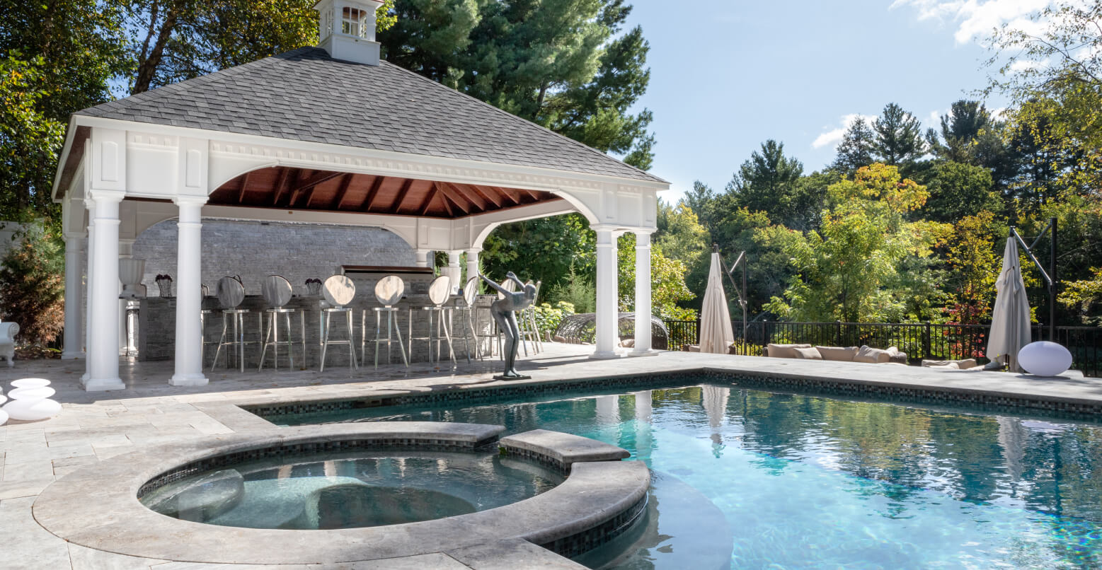 Pool with outdoor kitchen and bar under a cabana.