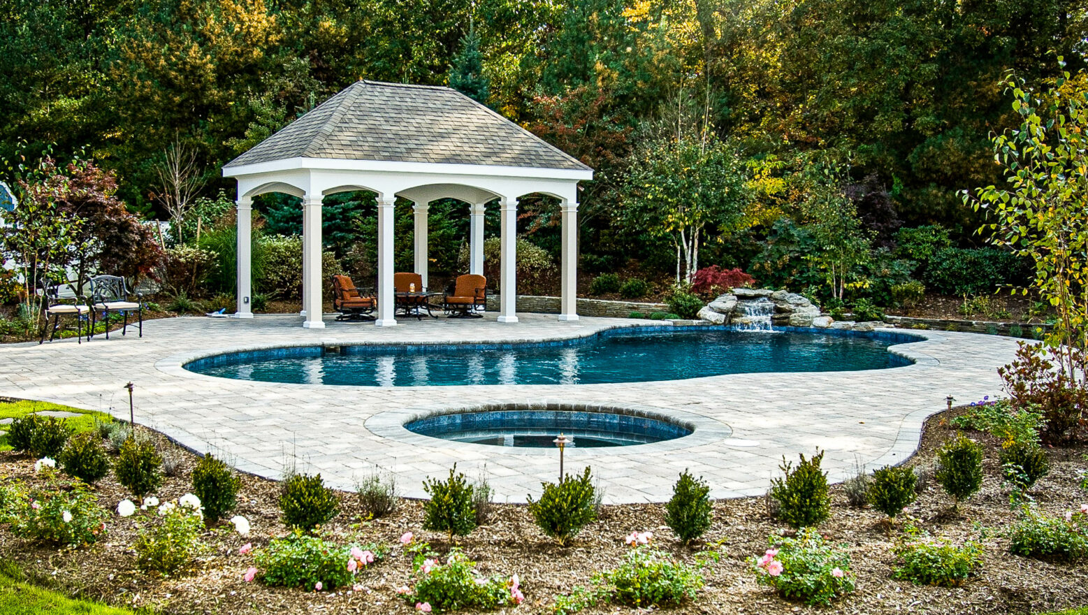 Pool with a water fountain and a cabana.