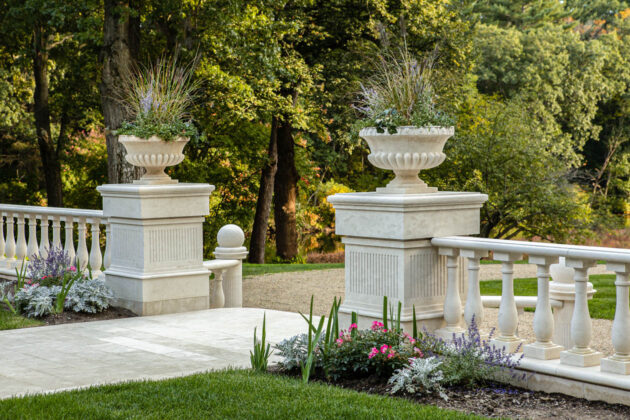 Marble columns with planters on top flanking courtyard walkway. Dex by Terra landscape design-build in Natick, Massachusetts.