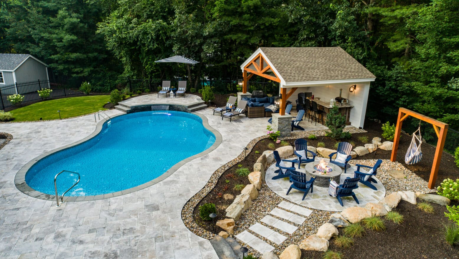 Drone shot of a new Dex By Terra pool deck, patio and fire pit in Whittinsville MA.