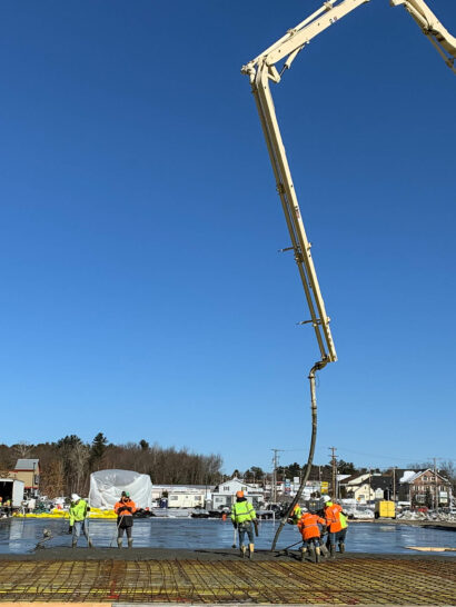 Workers with a crane doing flatwork.