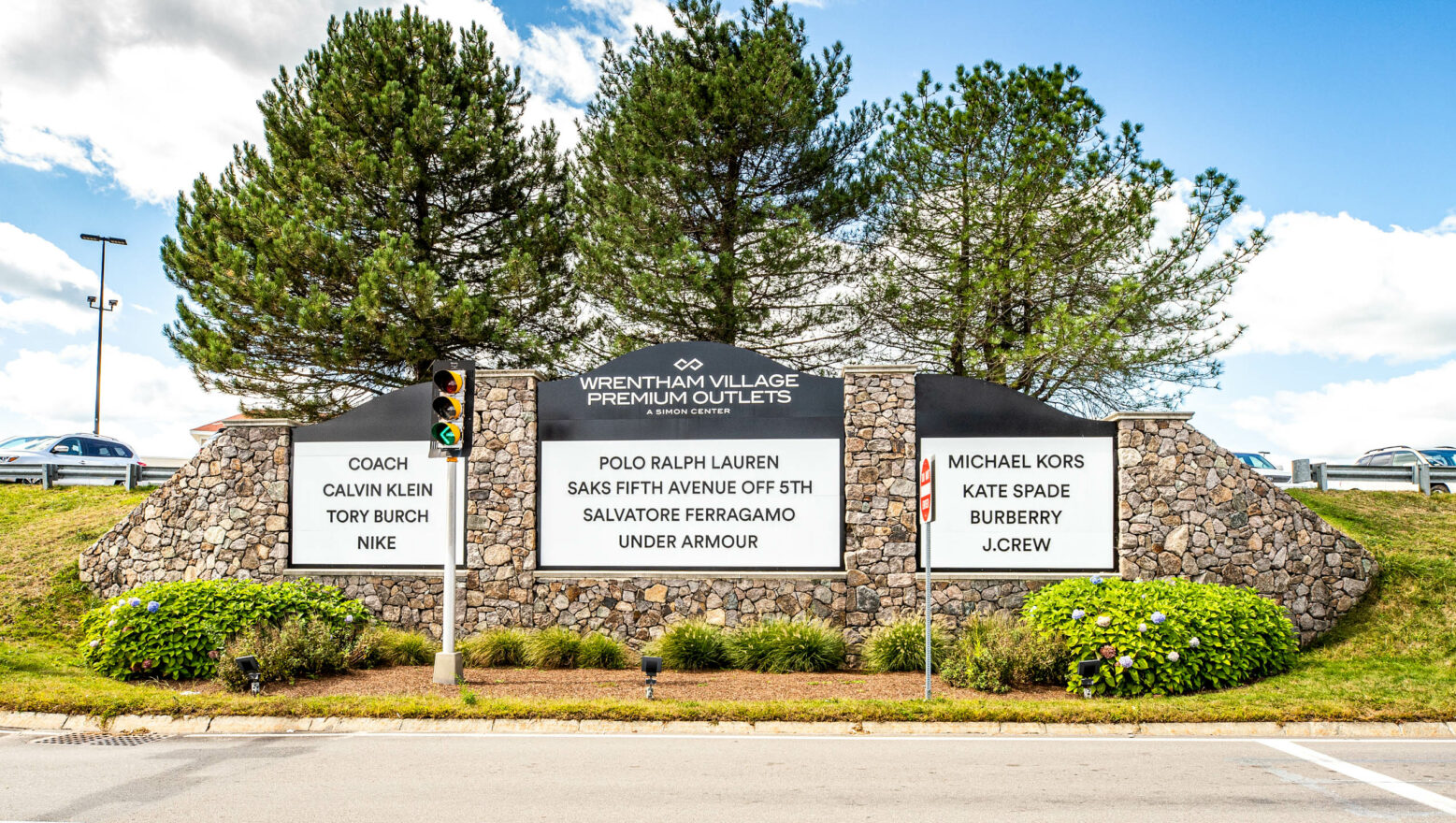 Wrentham Outlets Main Entrance Sign made with stone veneer. Dex by Terra commercial masonry, hardscape, & landscape project.