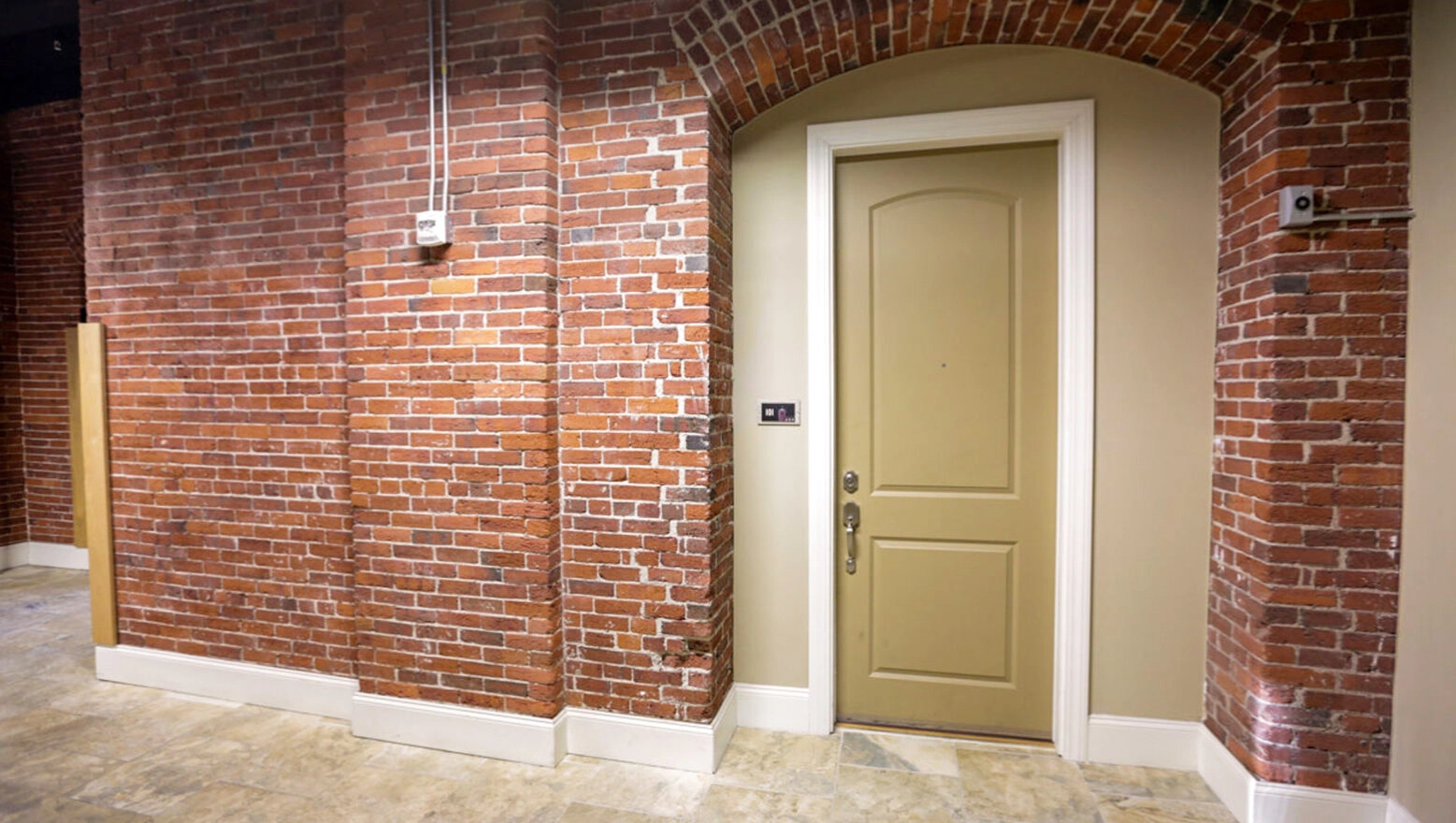 Interior Brick Wall with arched Doorway after restoration & repointing. Dex by Terra Commercial Masonry project.