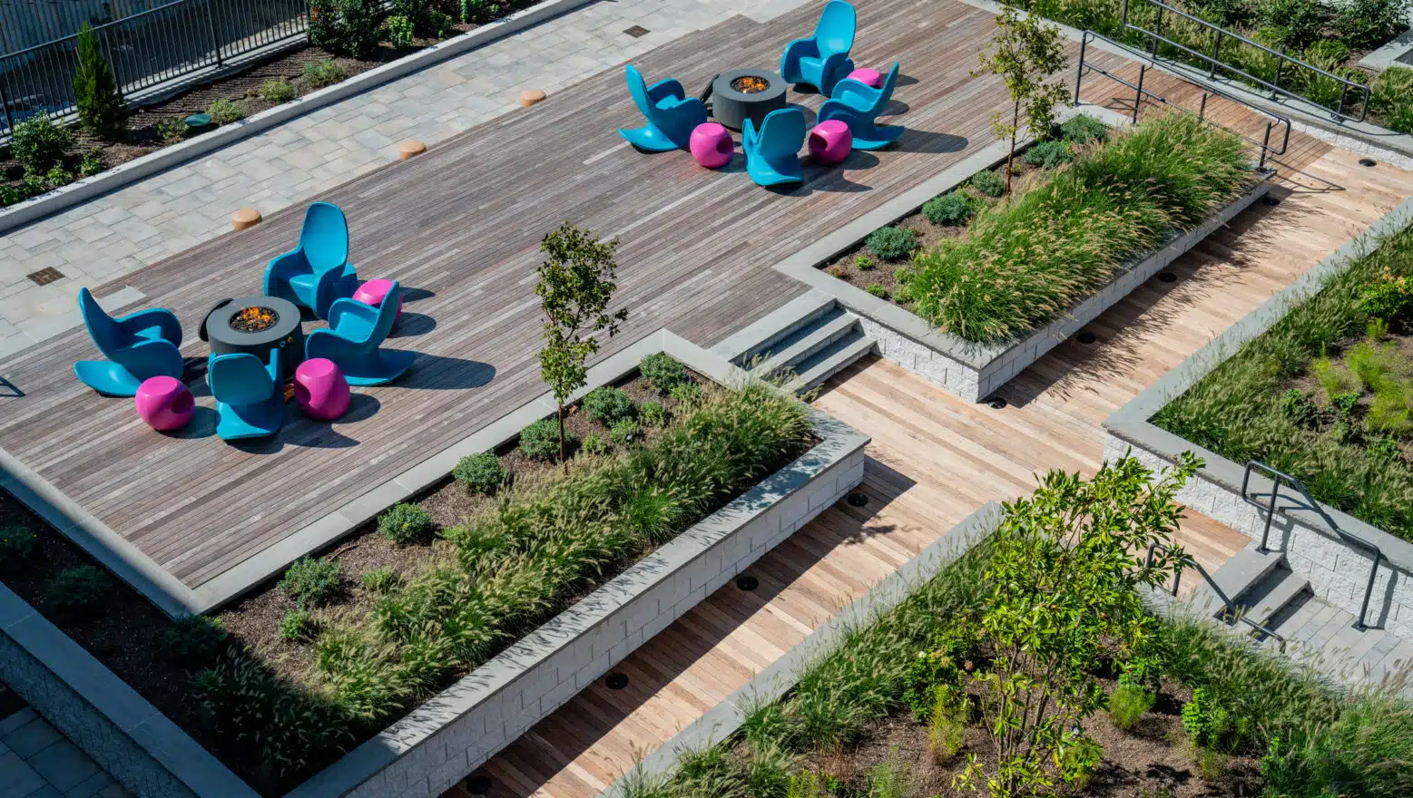 Deck, fire pits, & raised flower beds at V2 Apartments in Chelsea, MA. Commercial hardscape & landscape work by Dex by Terra.